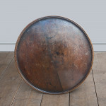An early 19th century oak tripod table with baluster column and circular tray top.